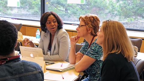 Three Data Wise participants converse at a table at HGSE.